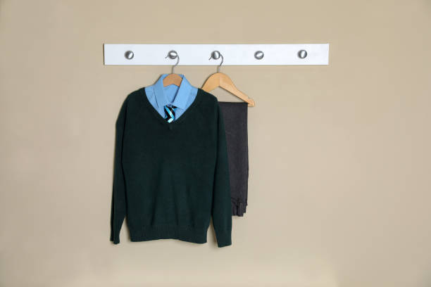 Shirt, jumper and pants hanging on beige wall. School uniform SCHOOL COLLECTION6 - Image 1